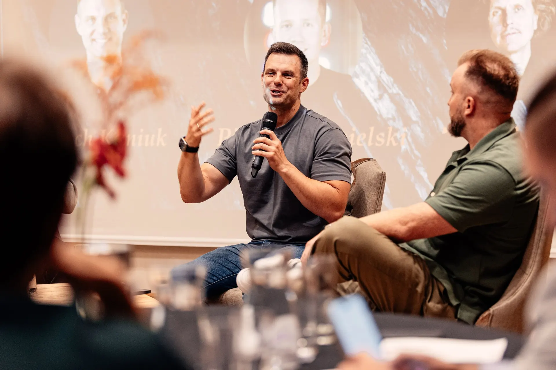 Lech Kaniuk on a conference panel, microphone in hand